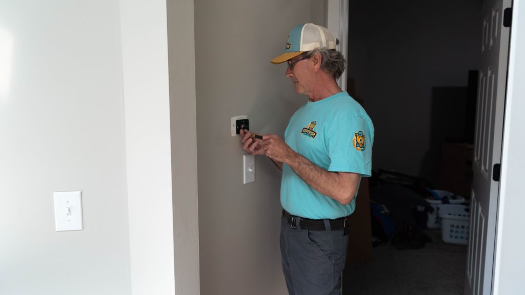 Superior Comfort technician working on thermostat