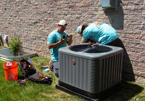 Two Superior Comfort installers installing a new Rheem air conditioner